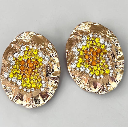 Gold hammered statement stud earrings with yellow, orange and clear rhinestone cluster detail.